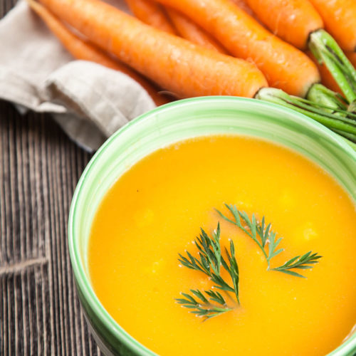 Photo of bowl of miso carrot soup with fresh carrots